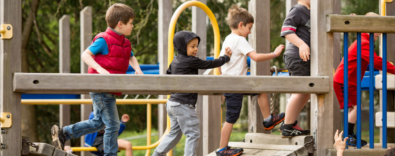 A group of children on a wooden play structure.