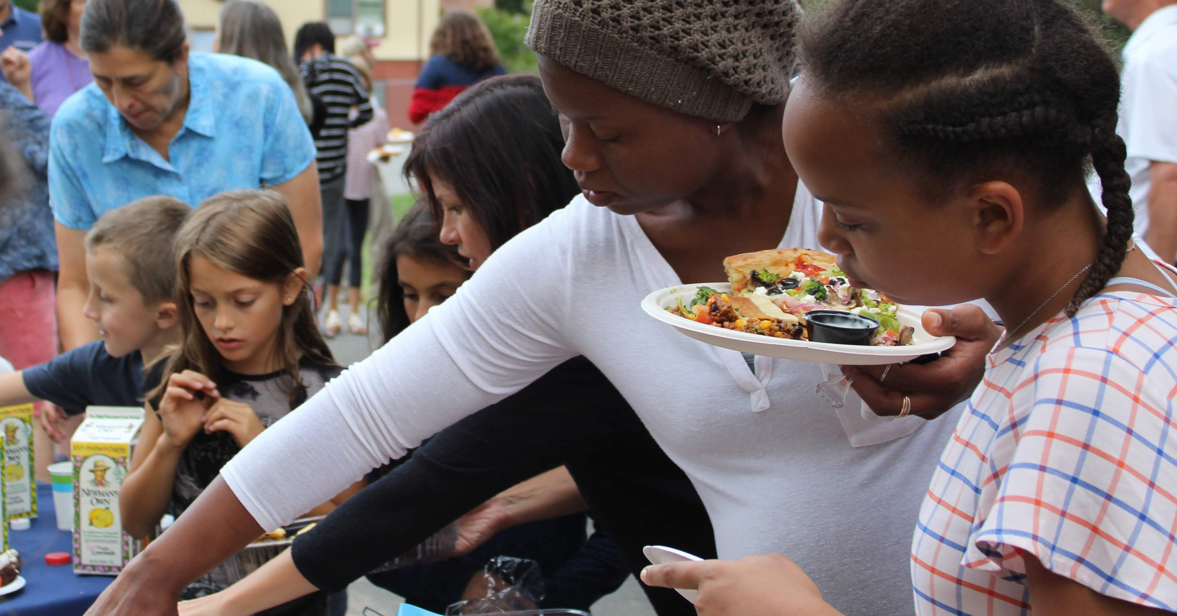 Families enjoying food at a potluck