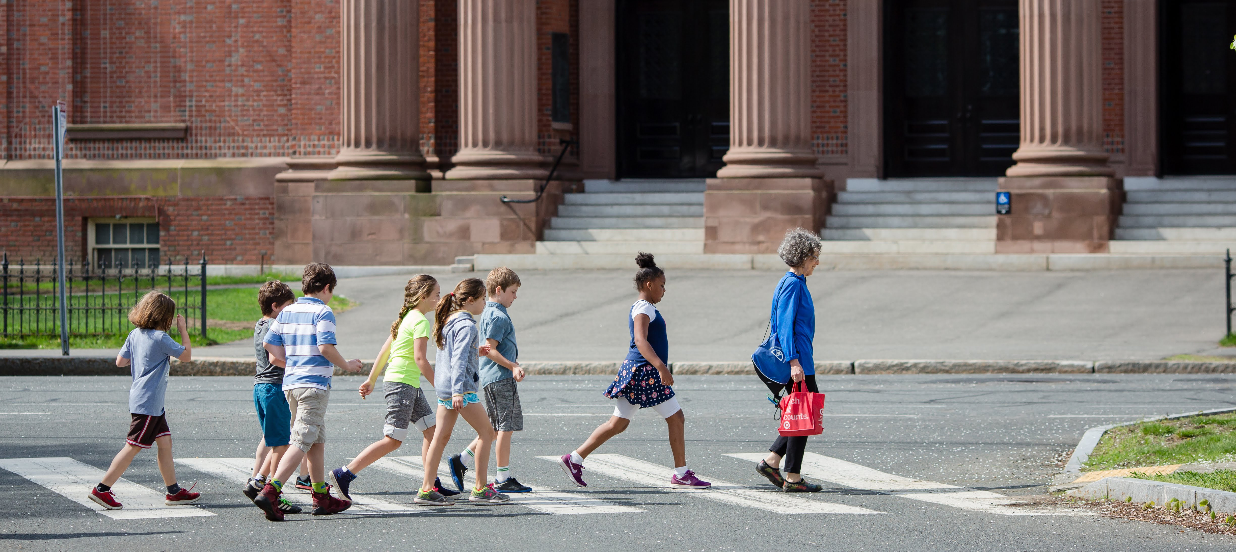 students crossing the street to go to John M. Greene Hall 