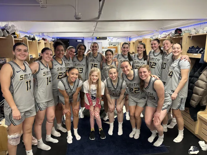 Smith's basketball team with a young fan